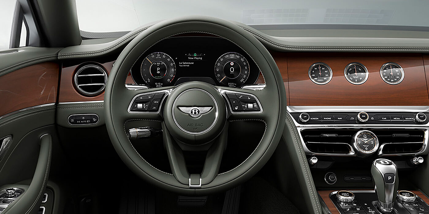 Bentley Hong Kong - DCH New Bentley Flying Spur sedan front cabin in Cumbrian Green hide and Crown Cut walnut veneer showing steering wheel and Rotating Display with three clocks on face