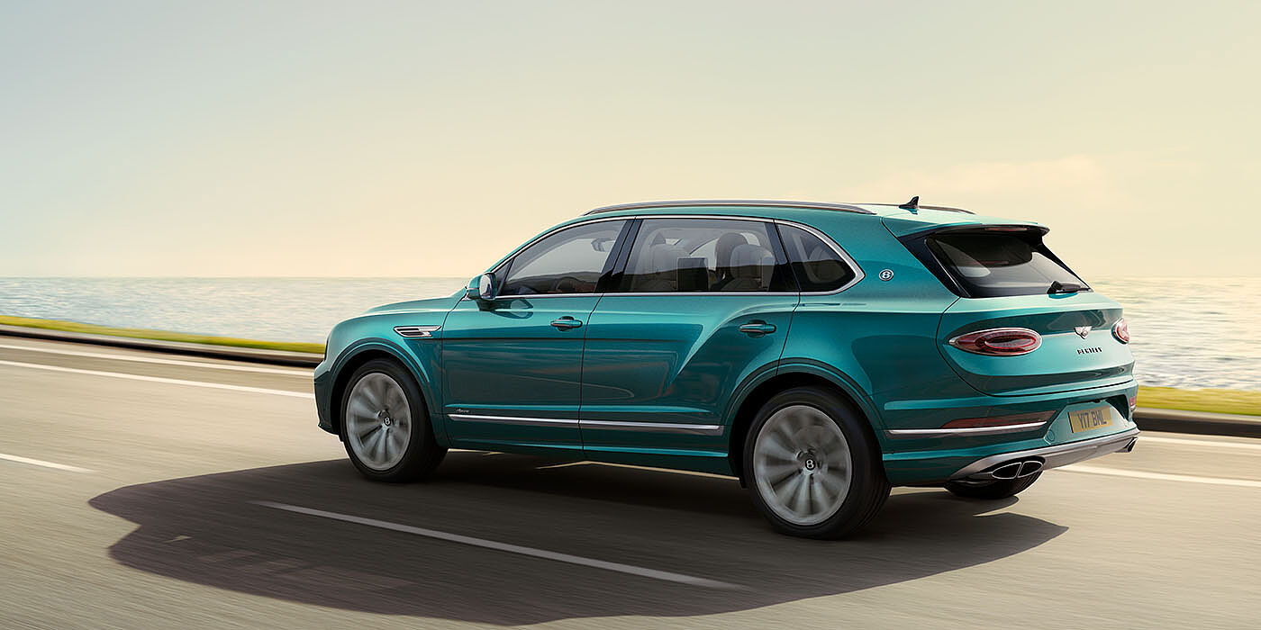 Bentley Hong Kong - DCH Bentley Bentayga Extended Wheelbase Azure luxury SUV rear three quarter in Topaz Blue by Mulliner paint, driving on an ocean road.