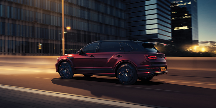 Bentley Hong Kong - DCH Bentley Bentayga Extended Wheelbase Mulliner SUV in Cricket Ball red paint driving dynamically in city at night