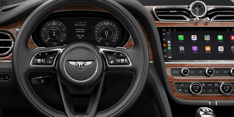 Bentley Hong Kong - DCH Bentley Bentayga SUV front interior detail of steering wheel and driver screens surrounded by Beluga black hide and Crown Cut Walnut veneer