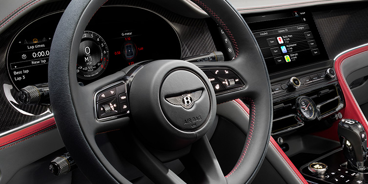 Bentley Hong Kong - DCH Bentley Flying Spur Speed sedan front interior detail showing steering wheel and driver screens surrounded with Hotspur red and Gravity Grey hides